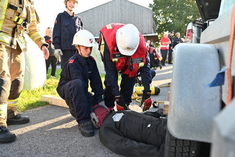 Mit vereinten Kräften konnten die Jugendlichen, die verletzte Person unter dem Silo-Ballen bergen. - Zusammenhalt dreier Feuerwehren - Zusammenhalt dreier Feuerwehren