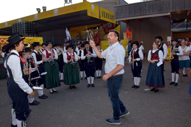Der Bürserberger Vize-Bgm. Ernst Wehinger dirigiert Musikantinnen und Musikanten aus seinem Heimatbezirk. - Fest "100 Jahre Blasmusikverband Vorarlberg"
