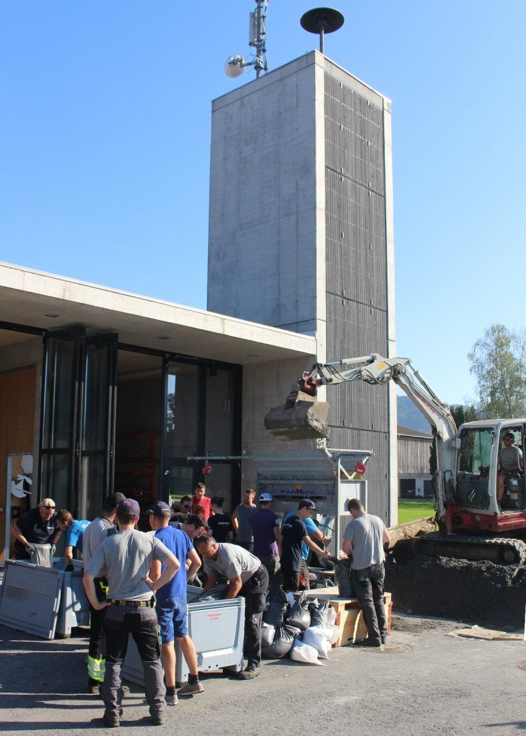Nachschub für Kampf gegen Hochwasser: Eingeübte Fließbandarbeit: ein Kleinbagger schaufelt Sand in die Abfüllanlage, in der die gefüllten Säcke zugenäht werden, ehe sie in Kunststoffboxen oder auf Paletten transportbereit gemacht werden.