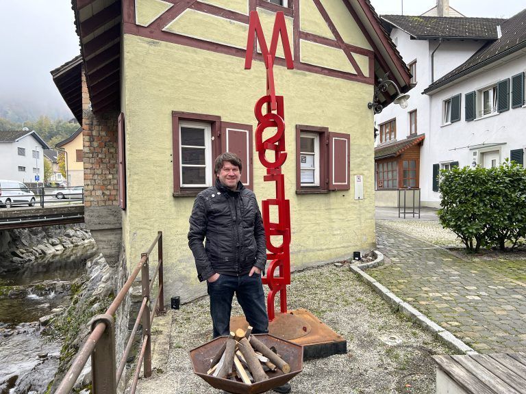 Künstler Edgar Büchel mit seiner Skulptur Marsfeuer am Emsbach