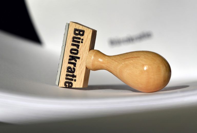 ABD0001_20241012 – POTSDAM – DEUTSCHLAND: ARCHIV – 12.02.2015, Brandenburg, Potsdam: Ein Stempel mit der Aufschrift ÇBrokratieÈ liegt auf Papieren. (Foto Illustration) (zu dpa: ÇMinisterium soll beim Brokratieabbau nacharbeitenÈ) Foto: Ralf Hirschberger/dpa-Zentralbild/dpa +++ dpa-Bildfunk +++. – FOTO: APA/dpa-Zentralbild/Ralf Hirschberger