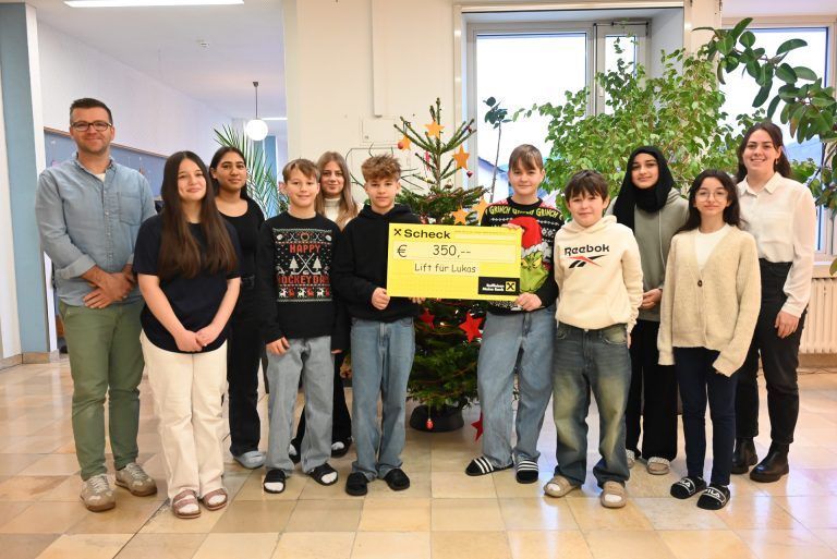 Stolz zeigten einige Schüler den Scheck, den sie dem Jungen überreichen, der einen Außenlift nach einem Schlaganfall benötigt. 