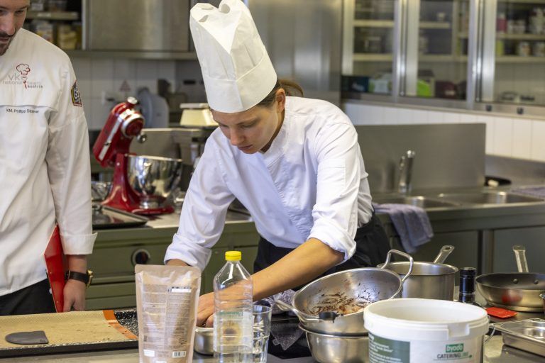 Finale der Junior-Master-Chef Zusatzausbildung an der Berufsschule für Gastronomie Fotos von den Kochlehrlingen beim Wettbewerb, von den drei Juroen und Wolfgang Ponier