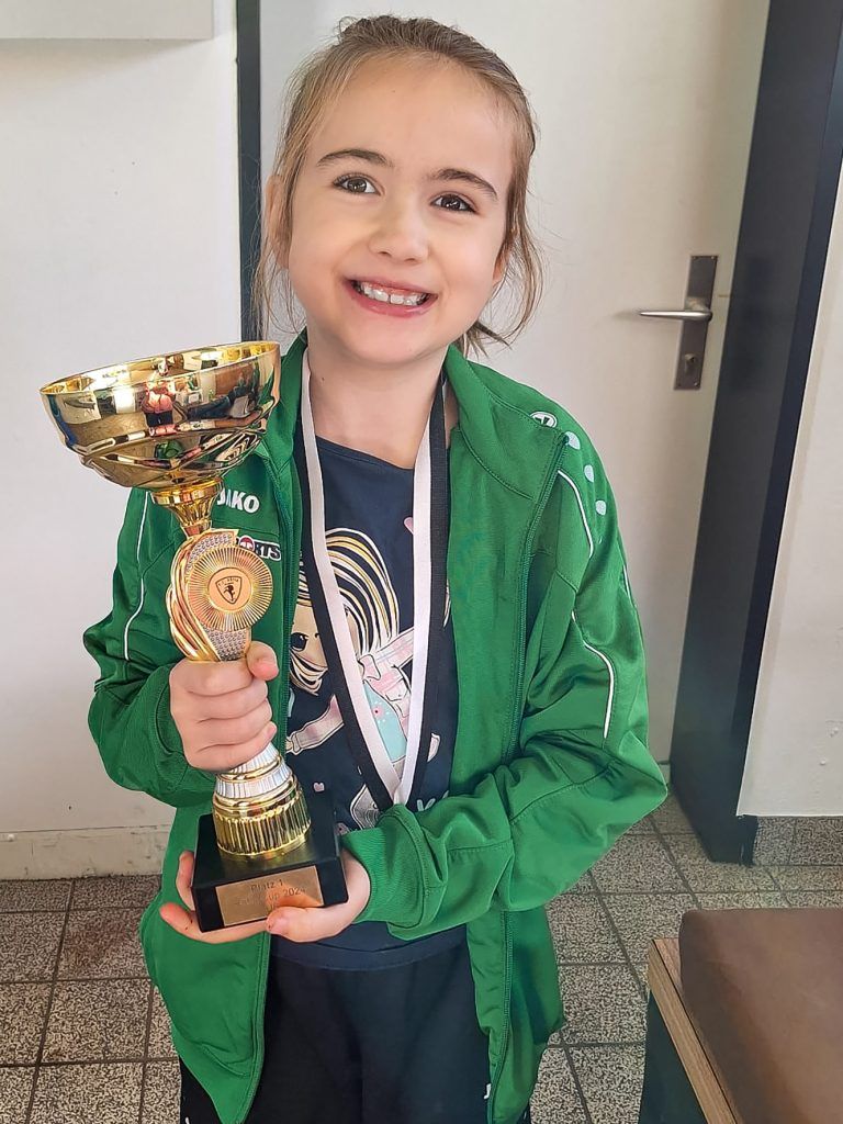 Dornbirner SV eröffnet neues Kapitel mit U13-Mädchenmannschaft: Stolz präsentiert Mia ihren Pokal und freut sich auf weitere Teamkolleginnen, die sich genau wie sie für Fußball begeistern.