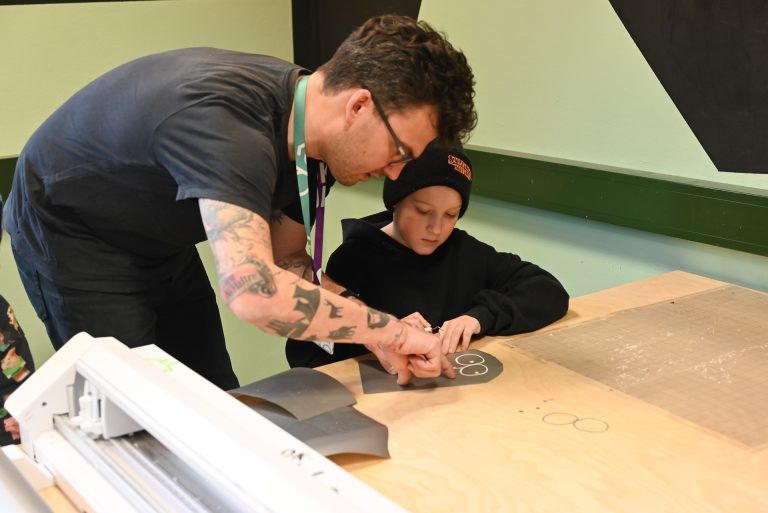 Kreativer Sticker-Workshop im dô: Florian Gerer vom dô zeigt den Kindern, wie ihre eigenen Sticker gestaltet werden können.