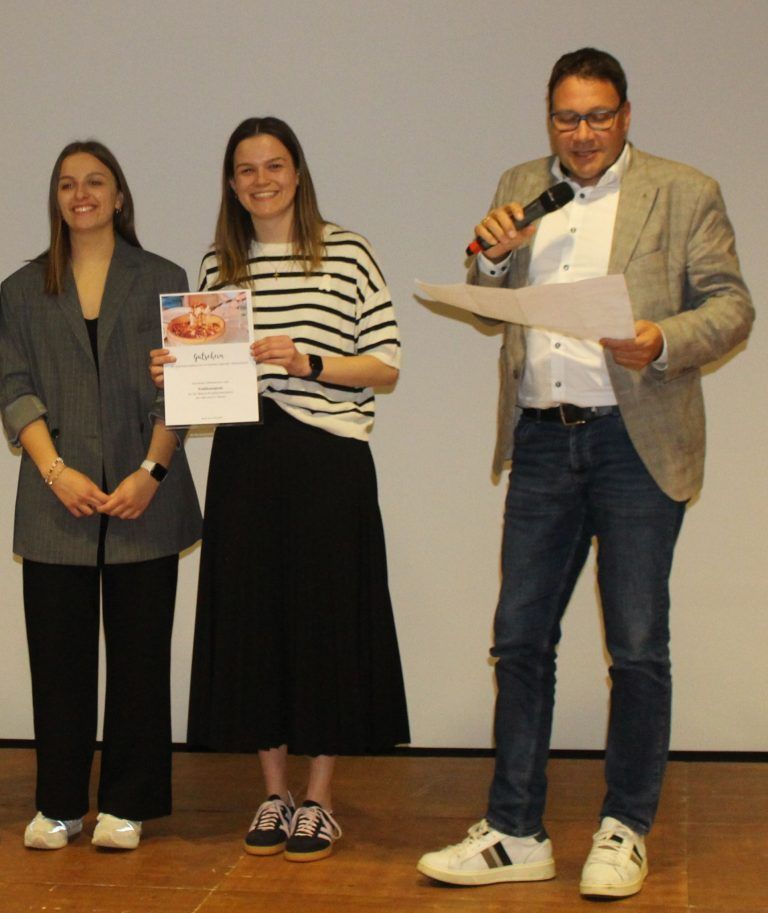 S’Café z’Büzo war Publikumsliebling: Stephan Fischnaller durfte den freudestrahlenden Maturantinnen Hannah Künzler und Paula Übelher den Gutschein für den Sieg in der Publikumswertung überreichen.