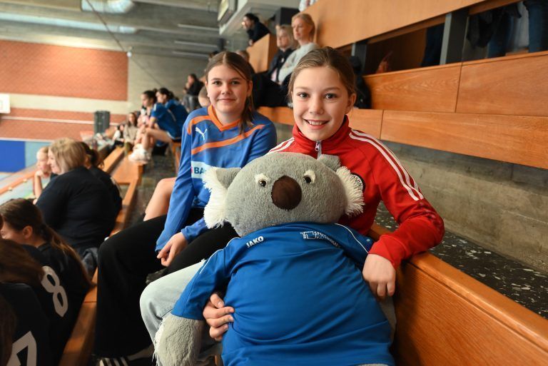 BRG Dornbirn Schoren gewinnt Handball-Schulcup der Mädchen : Naila (10) von der SMS Bregenz Schendlingen feuerte ihre Schule mit dem Klassenmaskottchen Berry an. Auch Pia (hinten) unterstützt ihr Team von der BG Blumenstraße.