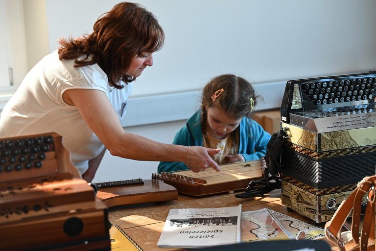 Breites Musikschulangebot kennenlernen: Interessiert spielte dieses Mädchen auf der Zither.