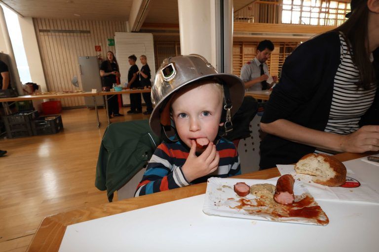 Neues Feuerwehrauto gesegnet und gefeiert: Mot Opas Helm auf dem Kopf ließ es sich auch Otti (3,5 Jahre) schmecken.