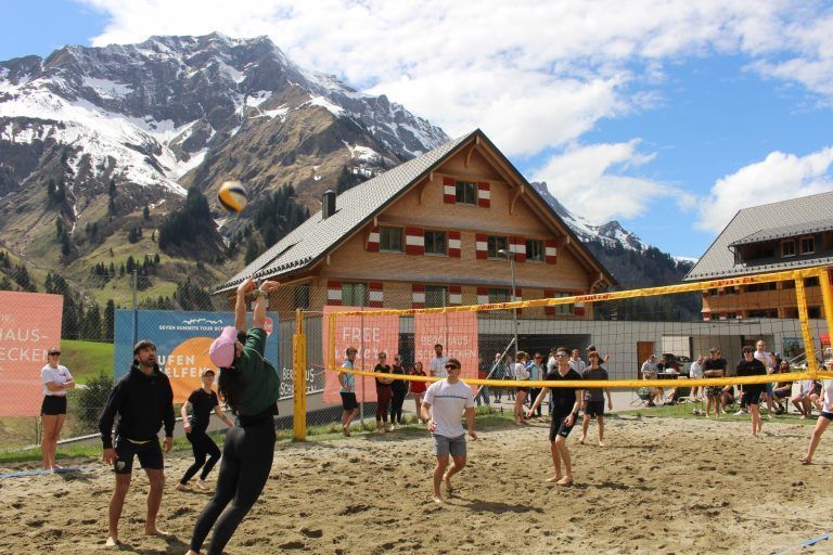 Berghaus – Begegnungszone statt kalte Betten: Beach-Volleyball in der Kulisse einer faszinierenden Bergwelt mit Hochberg (im Hintergrund) Künzelspitze, Rothorn, Mohnenfluh, Juppenspitze und Braunarl verbindet Urlaubsgäste und Einheimische.