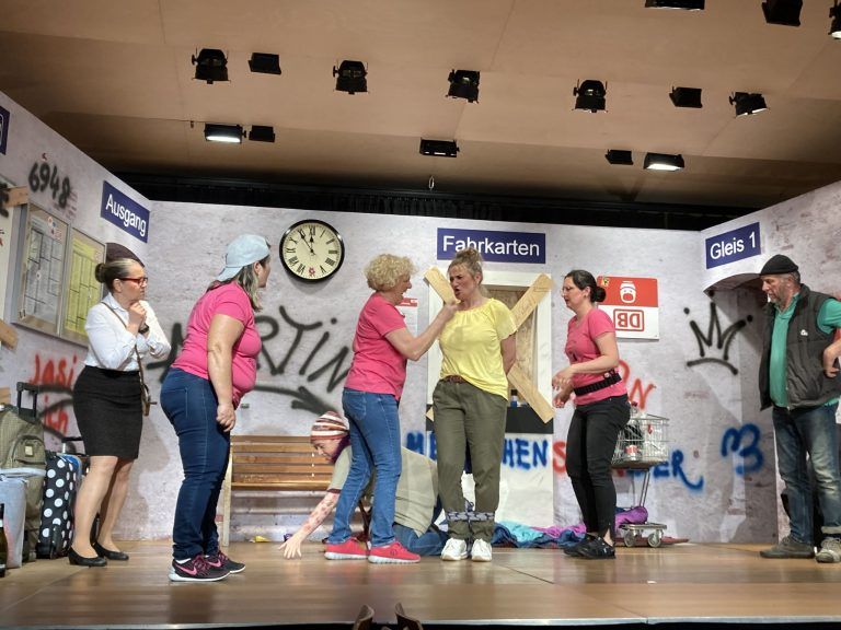 die Motivationstrainerin im gelben T-Shirt ist verdächtig - Beste Theaterunterhaltung im Theresienheim - Beste Theaterunterhaltung im Theresienheim