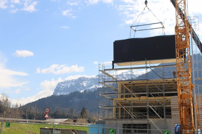 Kaufmann Bausysteme erweitert in Reuthe: Je nach Größe und Ausstattung sind die Module zehn bis 15 Tonnen schwer und werden mit dem Mobilkran in die vorgesehene Position gehievt. Bei diesem Projekt waren die Module rund zehn Tonnen schwer und maßen etwa elfeinhalb mal drei mal drei Meter.