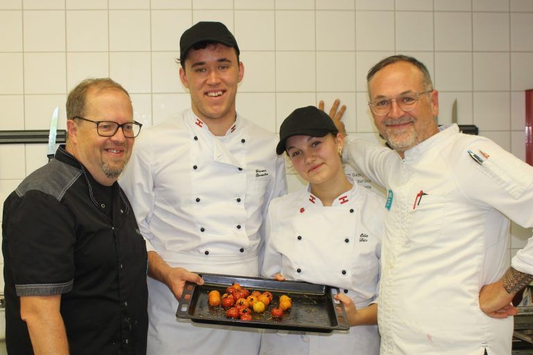 Eine Schule wird zum Haubenlokal: Florian Bereuter, bei zehn Kolleginnen Hahn im Korb, und Ella Dür konnten in der letzten Prüfungsrunde nicht nur ihre Gäste, sondern auch ihre Lehrer Thomas Pfeiffer (li.) und Martin Flatz voll überzeugen.