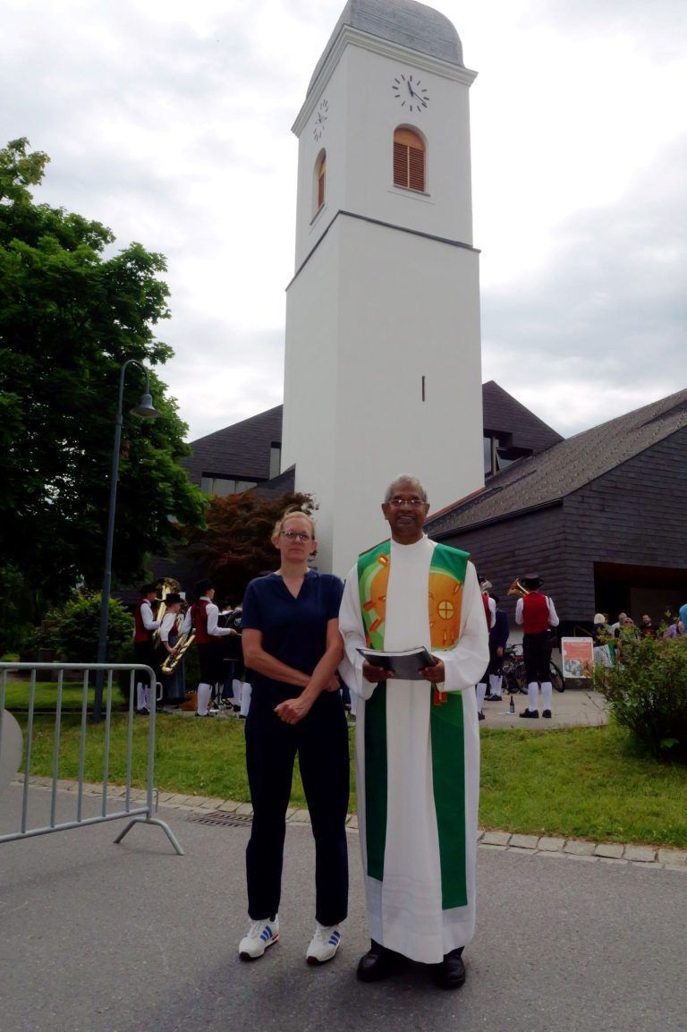 Kreuz, Kugel und Hahn in neuem Glanz: Restauratorin Nicole Mayer mit Pfarrer Georg vor dem frisch renovierten Kirchturm.