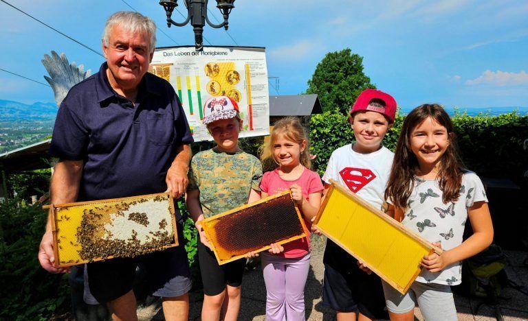 Exkursion ins Lochauer „Christbaumparadies Zussner“: Imker Wolfgang Schneider aus Möggers mit Chloe, Klara, Alan und Evelin beim Bienen-Lehr- und Schaukasten im Garten der Familie Zussner.