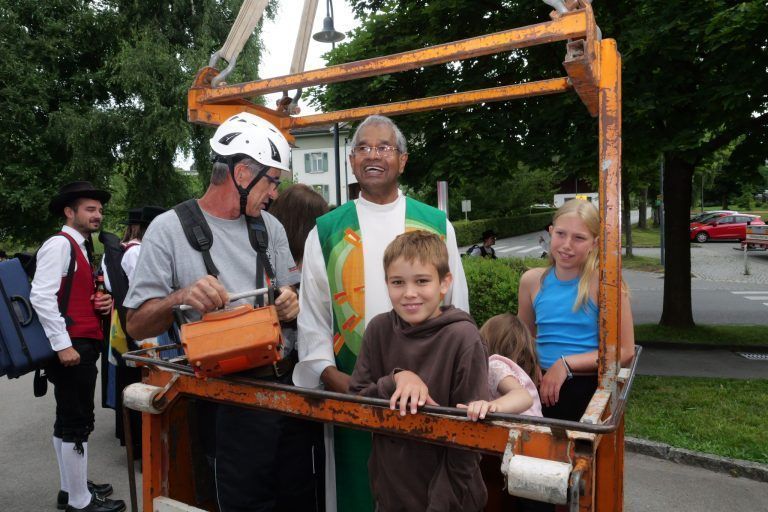 Kreuz, Kugel und Hahn in neuem Glanz: Pfarrer Georg mit Kindern auf dem Weg zur Kirchturmspitze.