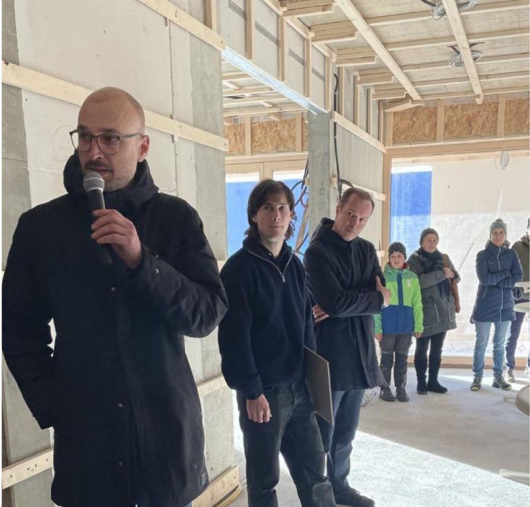 Von der Volksschule ins Lernhaus: Ständige Information der Bevölkerung: Sven Matt (mit Mikrofon), Tobias Franz und Markus Innauer (rechts) erläuterten Ende 2024 beim Rundgang durch das Gebäude und beim abschließenden Salongespräch in der Aula den Baufortschritt am Lernhaus.