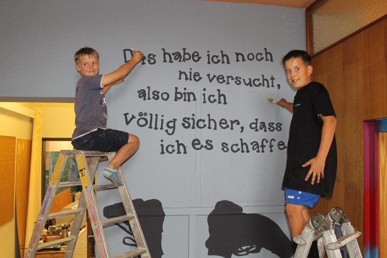 Unsere Schule ist schöner geworden: Gabriel Wetzel (l.) und Florentin Fessler präsentieren stolz einen tiefsinnigen Wandspruch im Stiegenhaus der Volksschule.