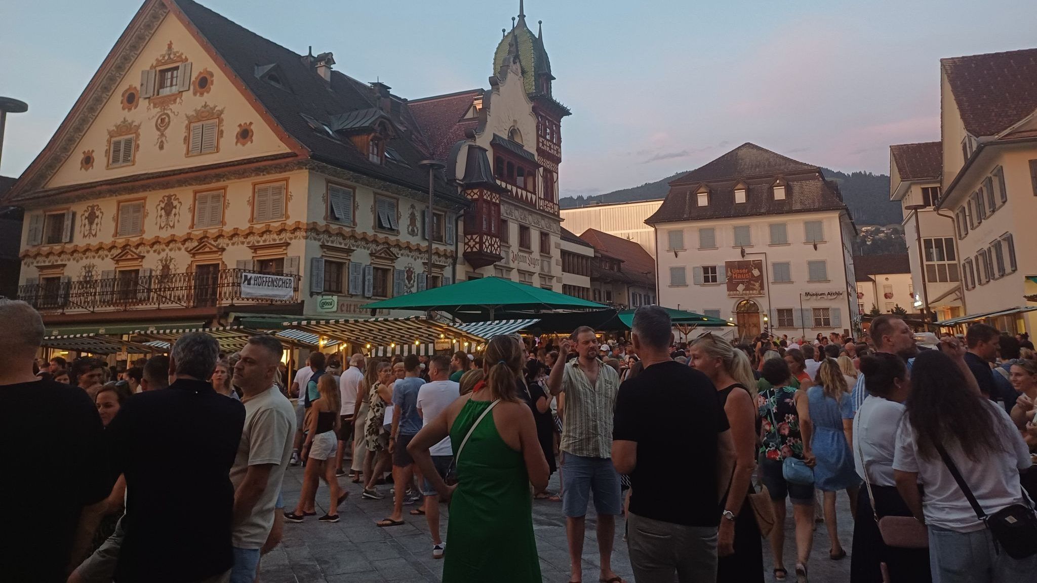 Besucher und Besucherinnen genießen Essen, Musik und das bunte Treiben auf dem Marktplatz.