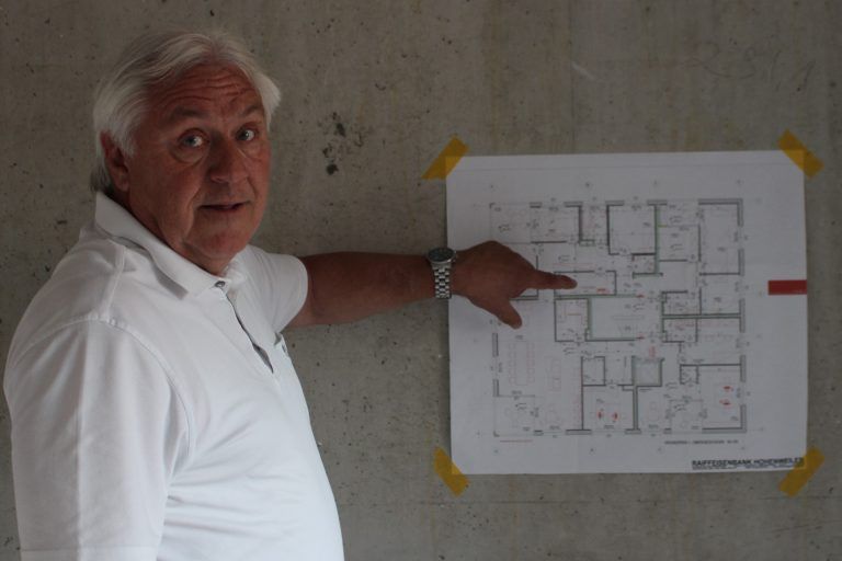 Sonnenkraftwerk auf gemieteten Dächern: Werner Hagen erläutert anhand des Planes, wie das erste Obergeschoss im "Raiffeisenhaus" der Hohenweiler Zentrumsverbauung auf die Bedürfnisse der Kinderdorf-Wohngruppe umgeplant und abgerstimmt wurde.