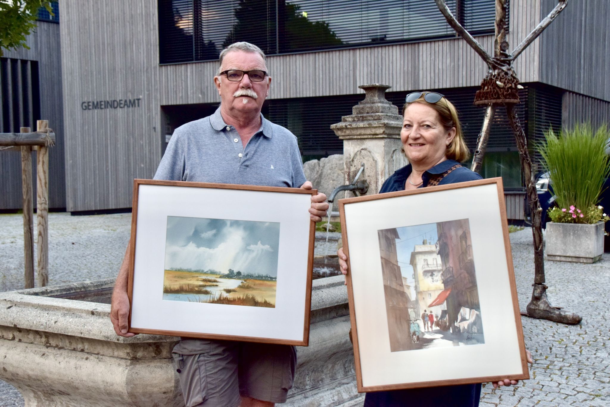 Elmar und Edith Frick aus Röthis mit Aquarellbildern, die Elmar Frick, ein gebürtiger Feldkircher, der in Frastanz aufgewachsen ist, geschaffen hat.