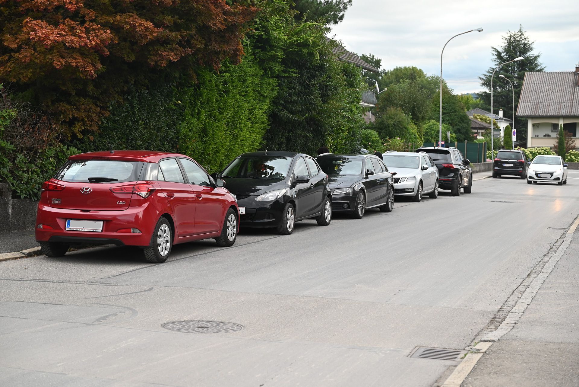 Eltern, die ihre Kinder mit dem Auto zur Schule bringen, parken am Straßenrand vom Bettleweg und begleiten die Kinder zu Fuß bis zur Schule.
