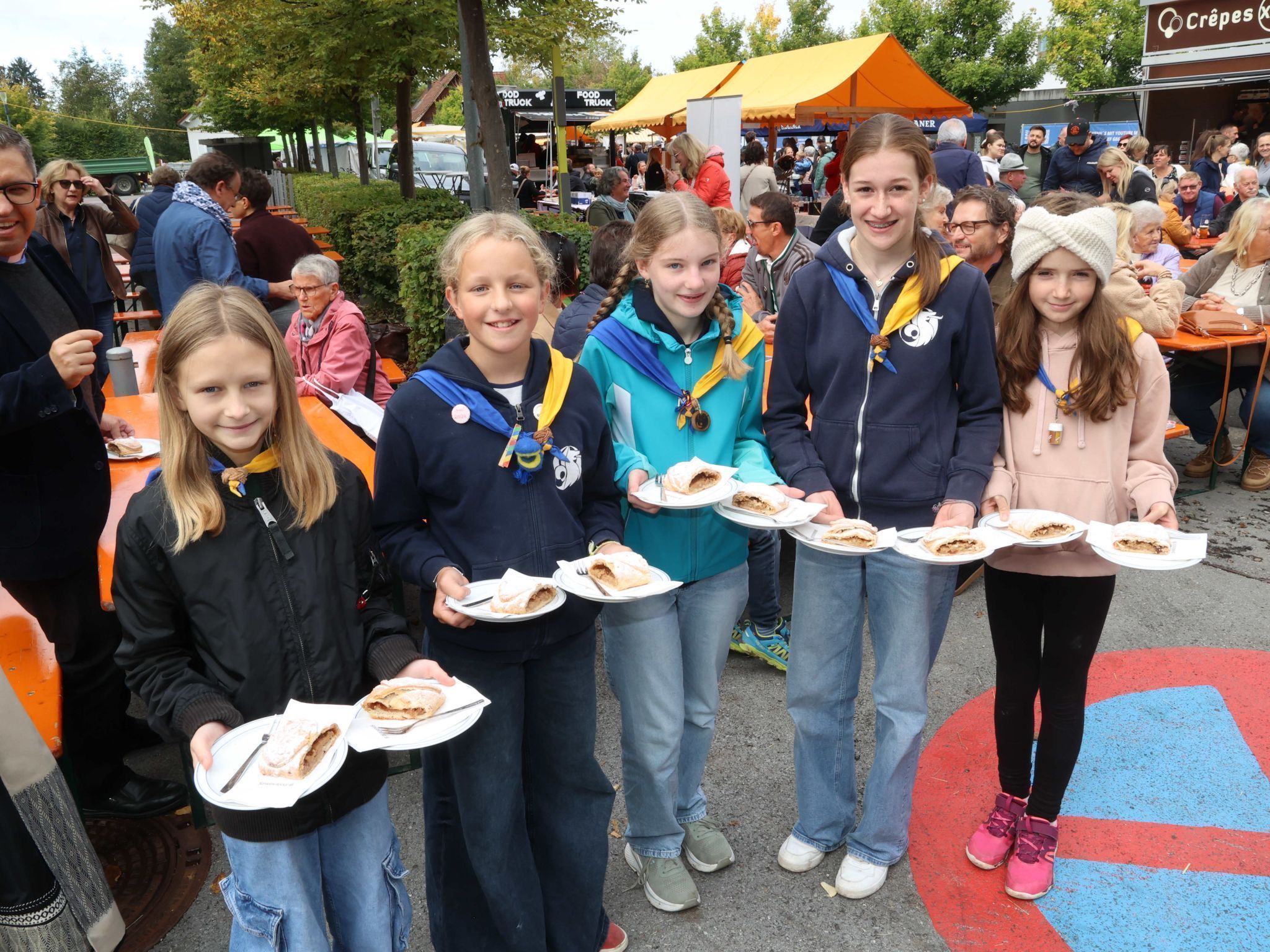 Pfadfinderinnen mit Apfelstrudel-Stücken.