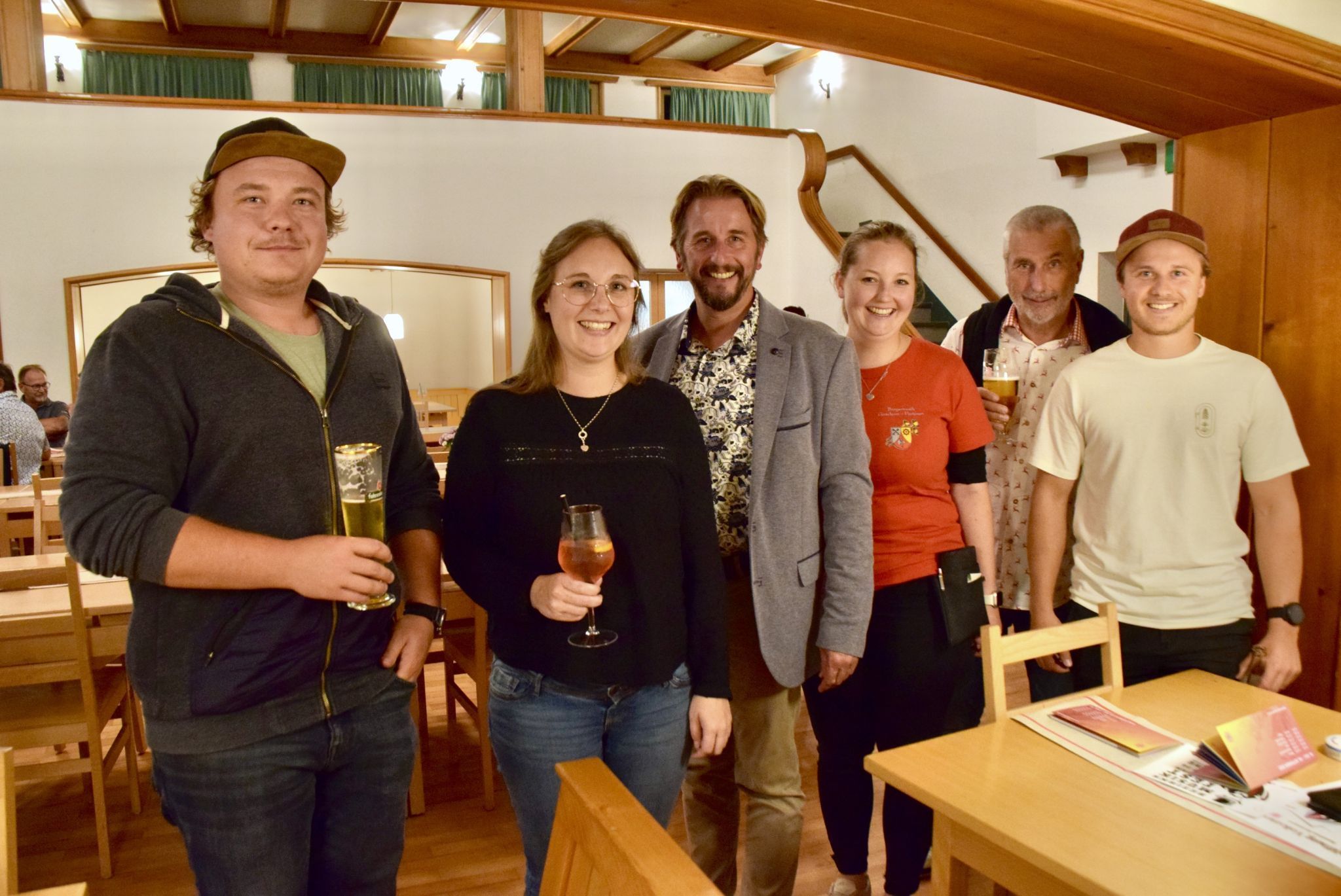Der Gaschurner Bürgermeister Daniel Sandrell, zugleich Standesrepräsentant (3. v. l.) mit einer Musikantin der Bürgermusik Gaschurn-Partenen (3. v. r.) und Besuchern des Eröffnungskonzertes der Volksmusiktage im Vallülasaal.