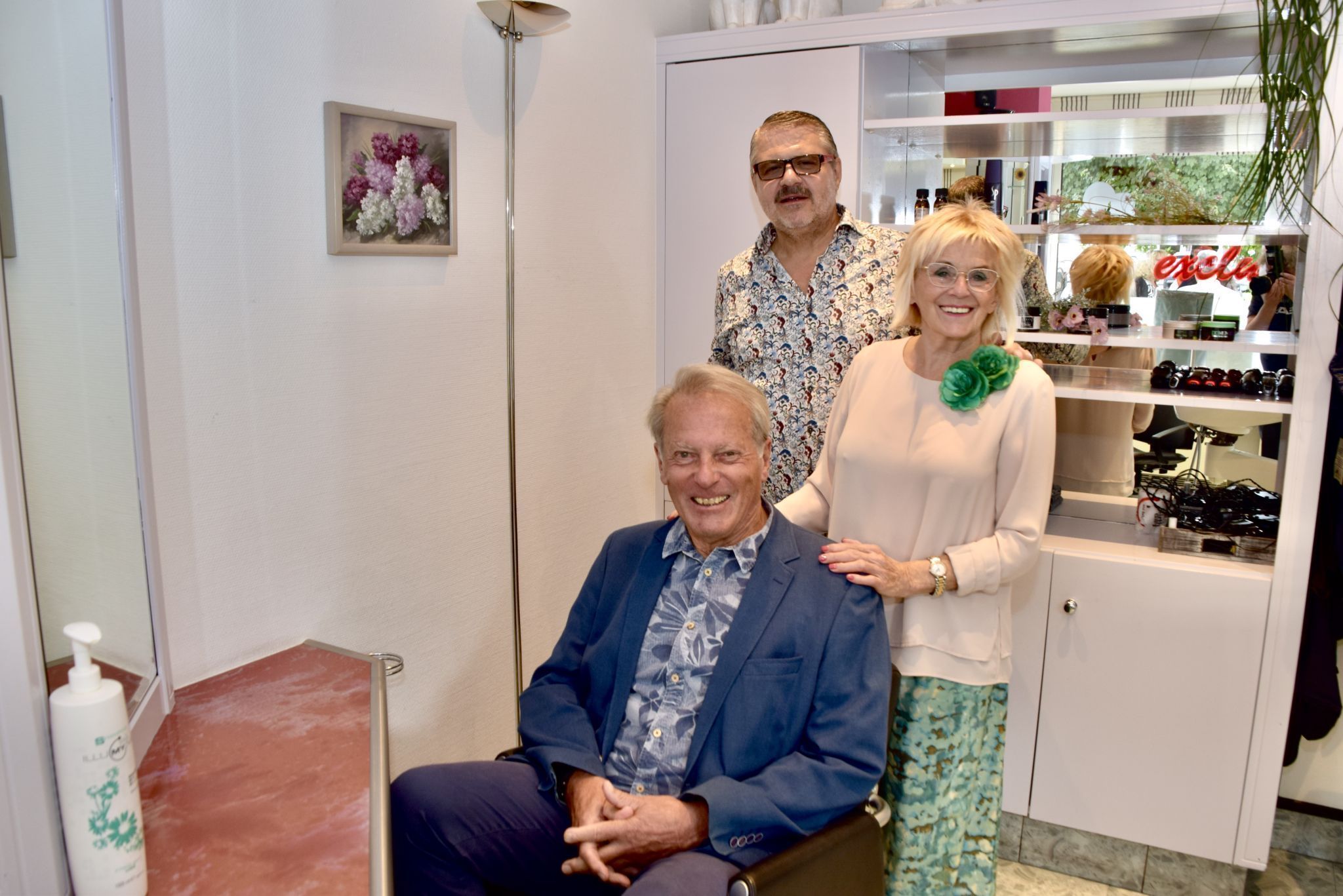 Friseurmeisterin Renate Piesl mit ihrem Ehemann Gerald Piesl und ihrem Stammkunden Karl Hueber im Friseurstuhl.