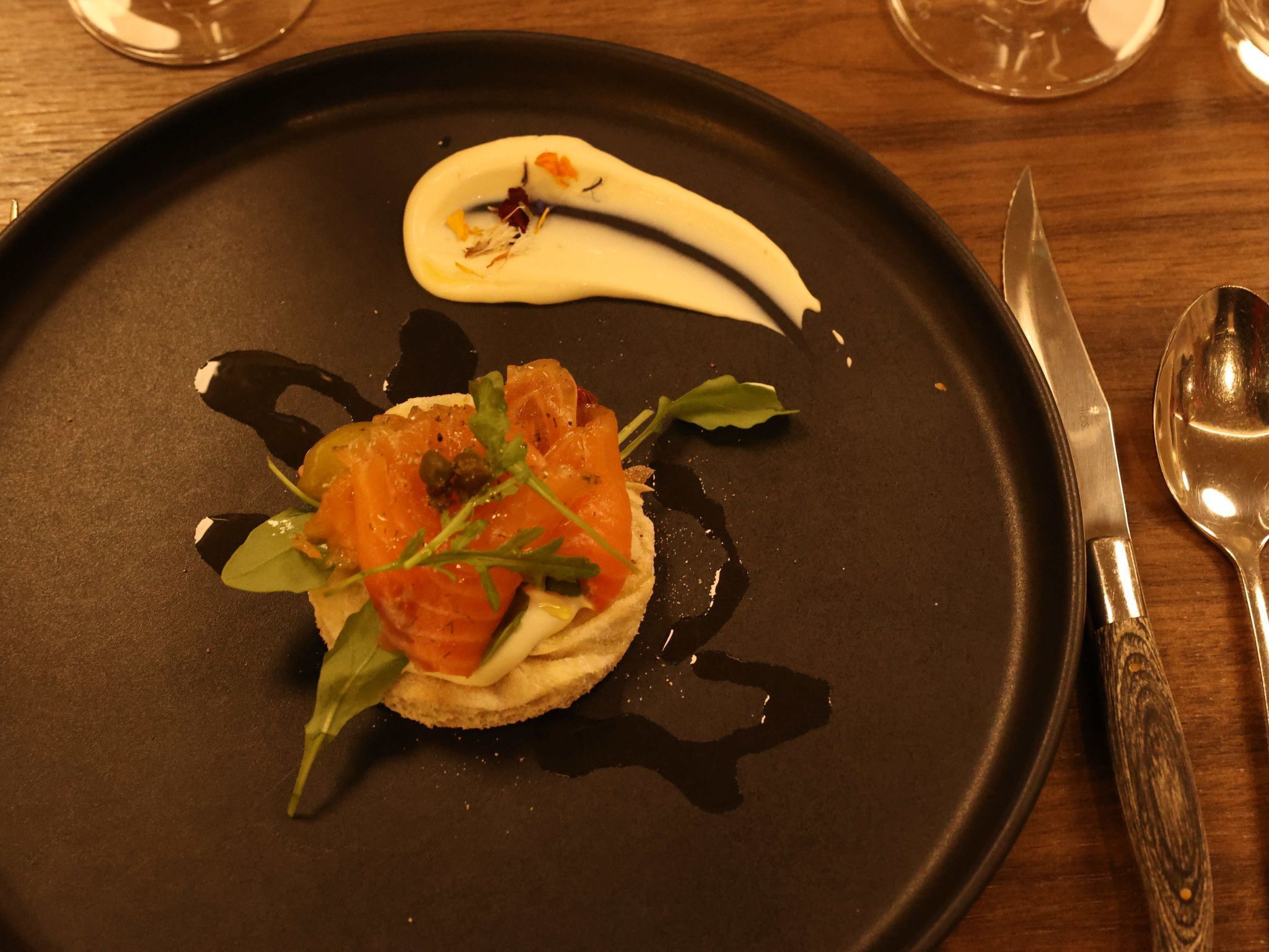 Der hausgebeizte Lachs mit Foccacia, Oliven, Sauerrahm und Rucola.