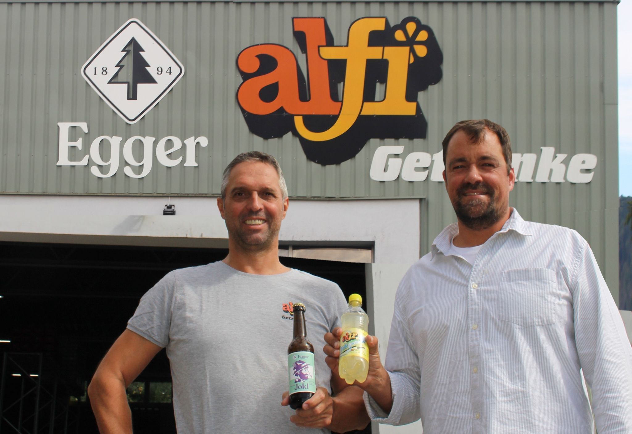 Joachim Fink (li.) und Lukas Dorner haben kürzlich den Wälder Getränke-Deal mit dem Egger-Logo auf der Alfi-Halle auch optisch vollzogen. PETER STRAUSS   