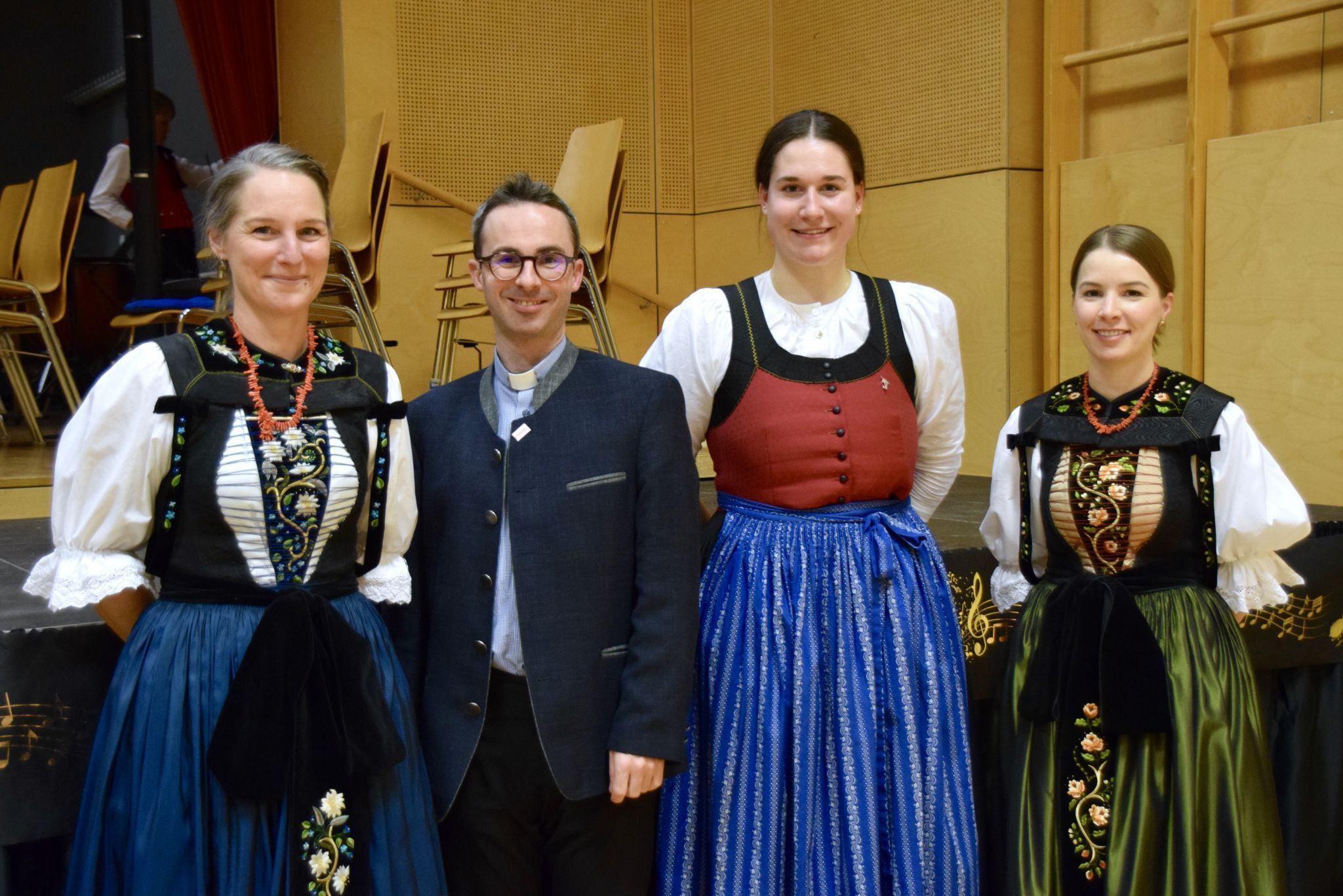 Pfarrer und Konzertmoderator Lukas Bonner mit den Marketenderinnen Kathrin (l.) und Stefanie (r.) sowie Musikantin Ronja (2. v. r.).