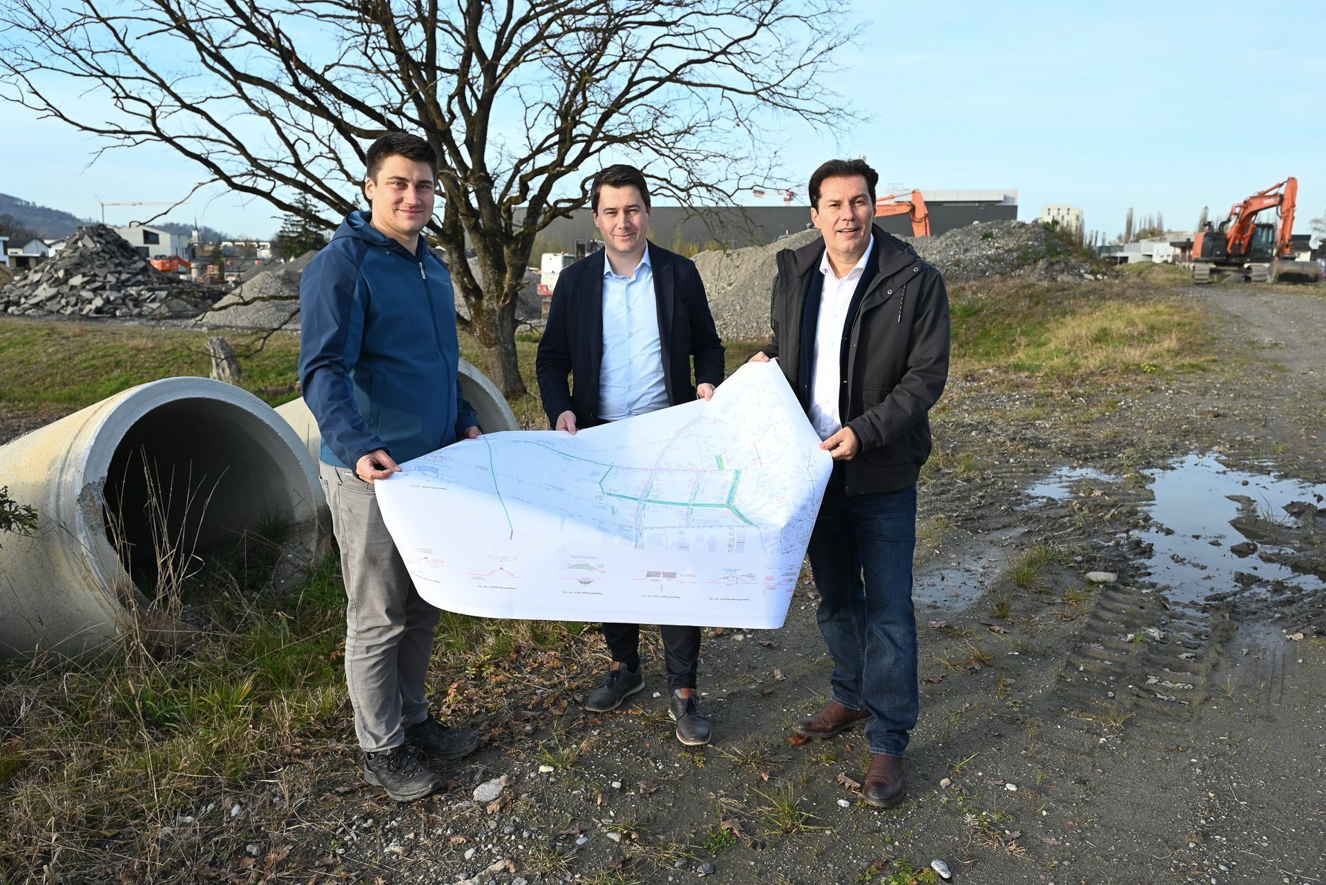 Tiefbauleiter Nicholas Hofer veranschaulicht Bürgermeister Patrick Wiedl und Vizebürgermeister Martin Fitz die Baupläne am neuen Betriebsgebiet Heitere.