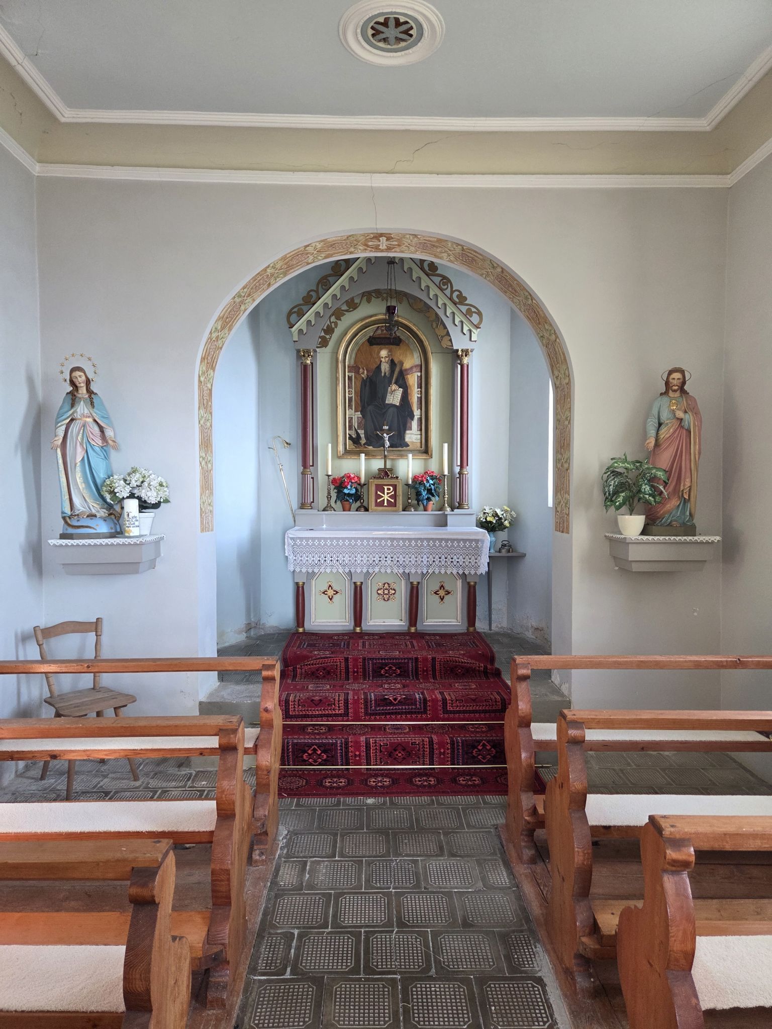 Apsis mit Gemälde des Hl. Benedikt und Chorbogen mit zwei Holzstatuen (Foto OS)