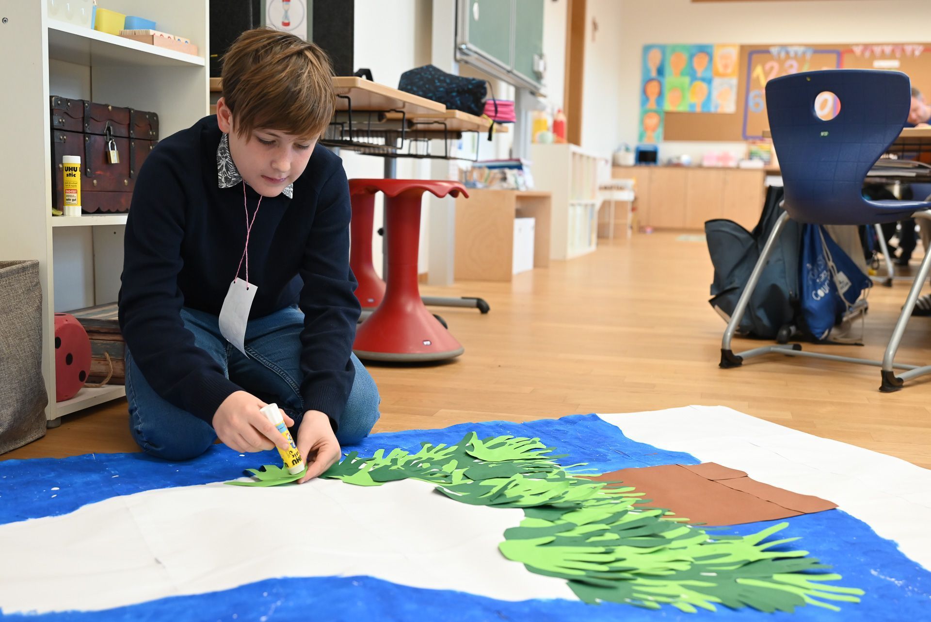 Jakob klebt gerade seine Hand auf den Baum.
