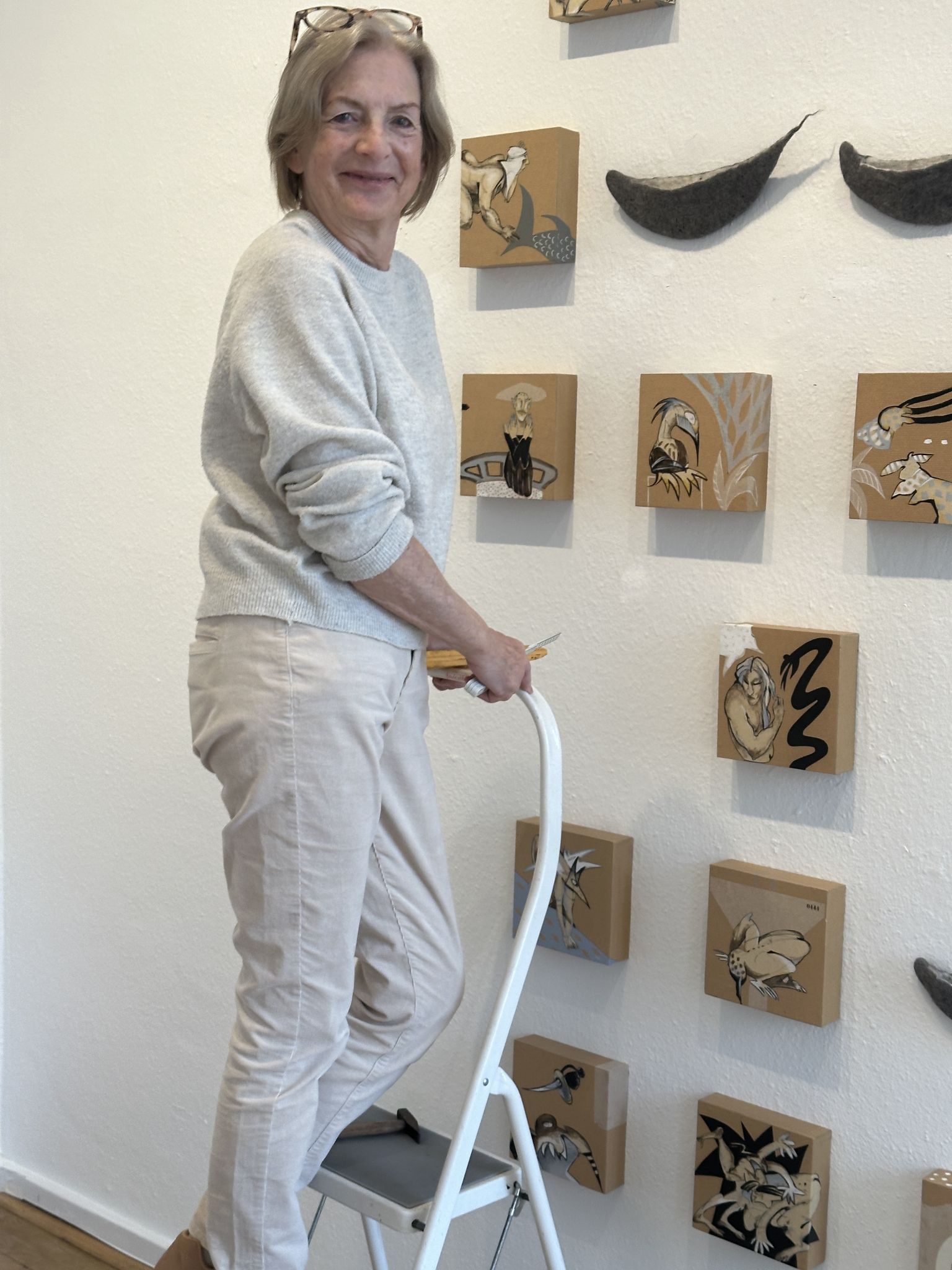 Lisa Althaus bei der Hängung der kleinteiligen Arbeiten, die eine besondere Schwierigkeit darstellen