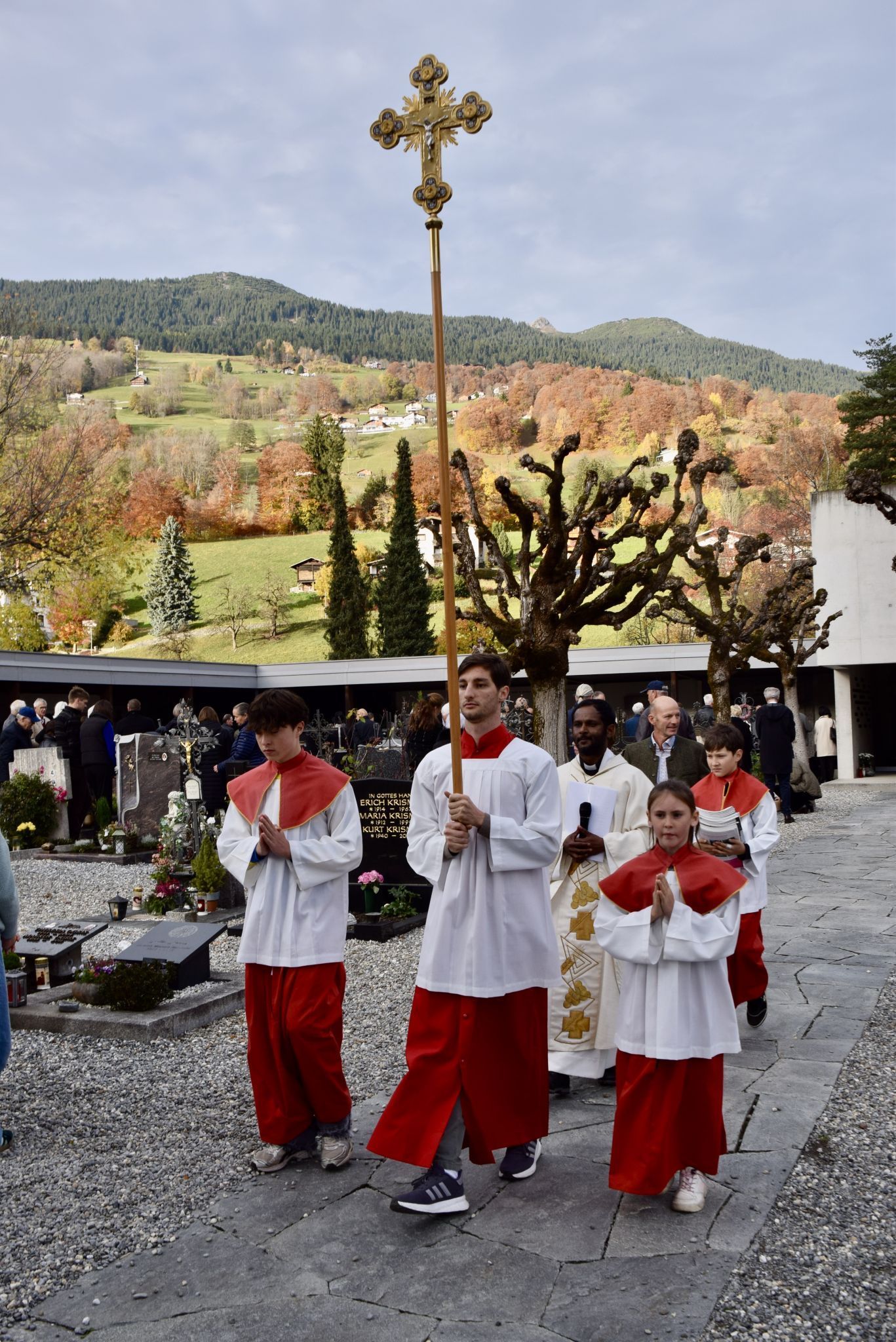 Kaplan Albert Joseph Jesuraj mit den Ministrierenden am Schrunser Friedhof, wo sie nach der Gräbersegnung um Spenden für das „Schwarze Kreuz - Kriegsgräberfürsorge“ baten.