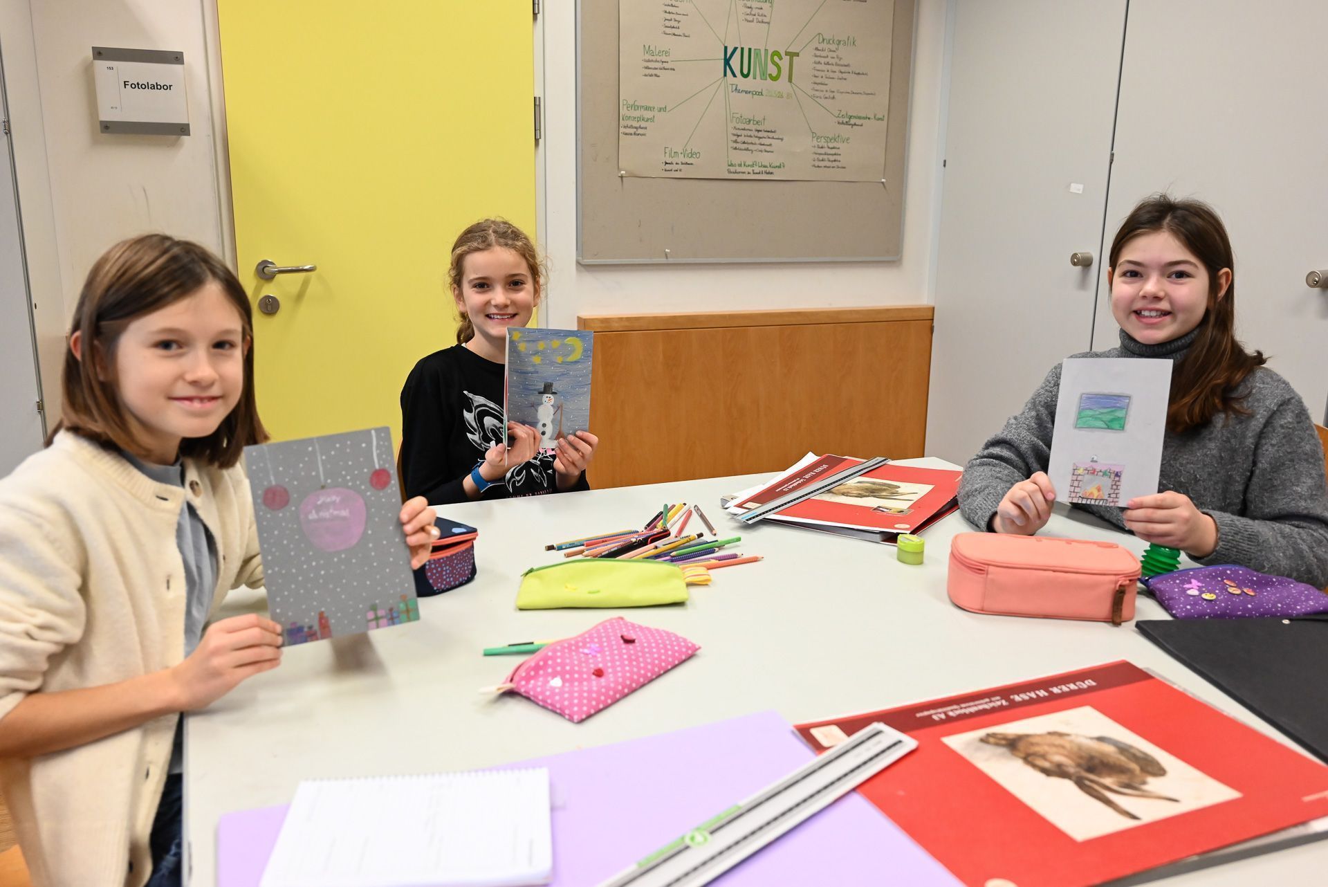 Lara, Amelie und Rosalinda zeigen stolz ihre Karten.