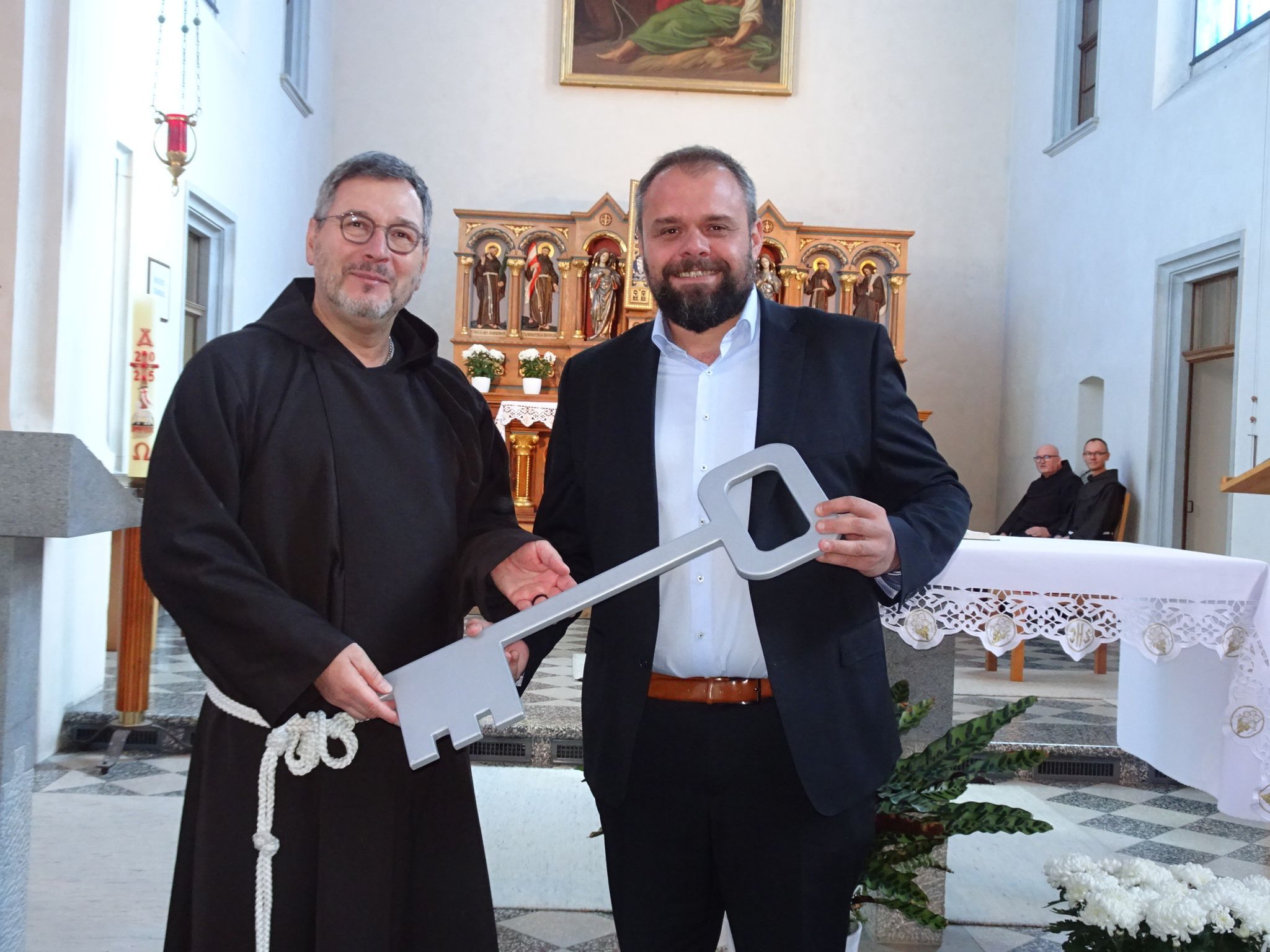 Bruder Helmut Rakowski (Provinzialminister der Kapuziner in Deutschland) mit dem symbolischen Schlüssel für Bürgermeister Markus Fäßler.