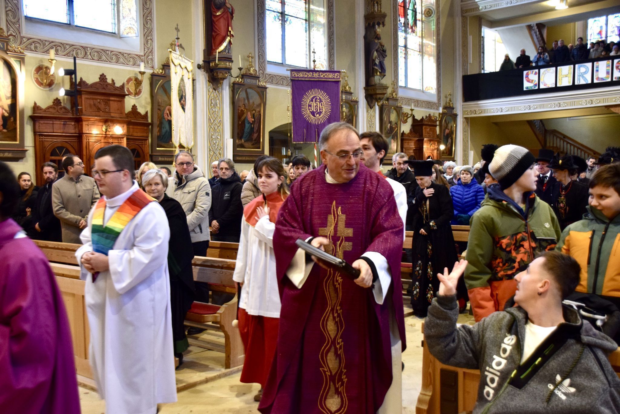 Pfarrmoderator Hans Tinkhauser zieht in das Schrunser Münster ein - Dominik begrüßt ihn.