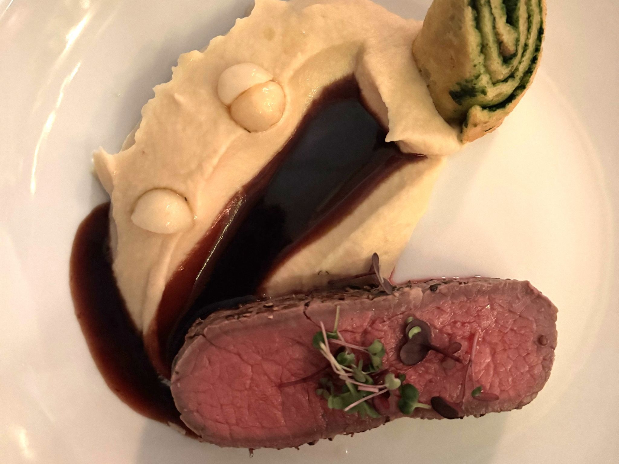rosa gebackenes Entrecôte vom Asaredo Beef mit Portweinjus, Selleriepüree und Kartoffel-Biskuitrollade.