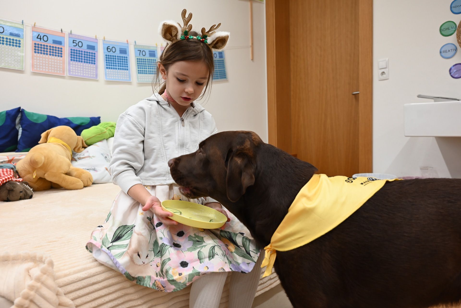 Die Kinder haben eine essbares Bild für Bobby auf einen Teller zusammengestellt und üben das freie Erzählen, während er sich die Zutaten schmecken lässt.