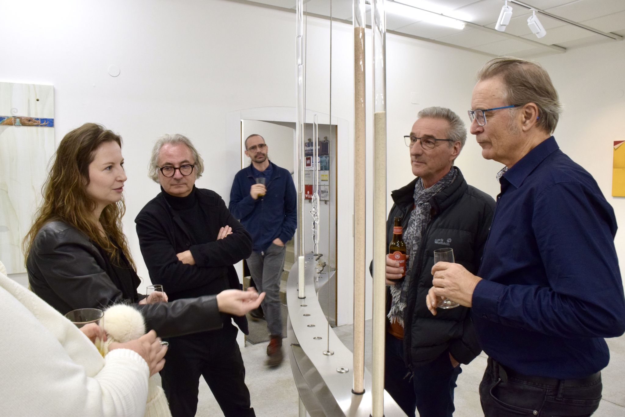 Bianca Phos erklärt Markus Mallin, Edgar Winkler und Roland Haas ihr größtes Kunstwerk, welches sie im Kunstforum Montafon ausstellt.
