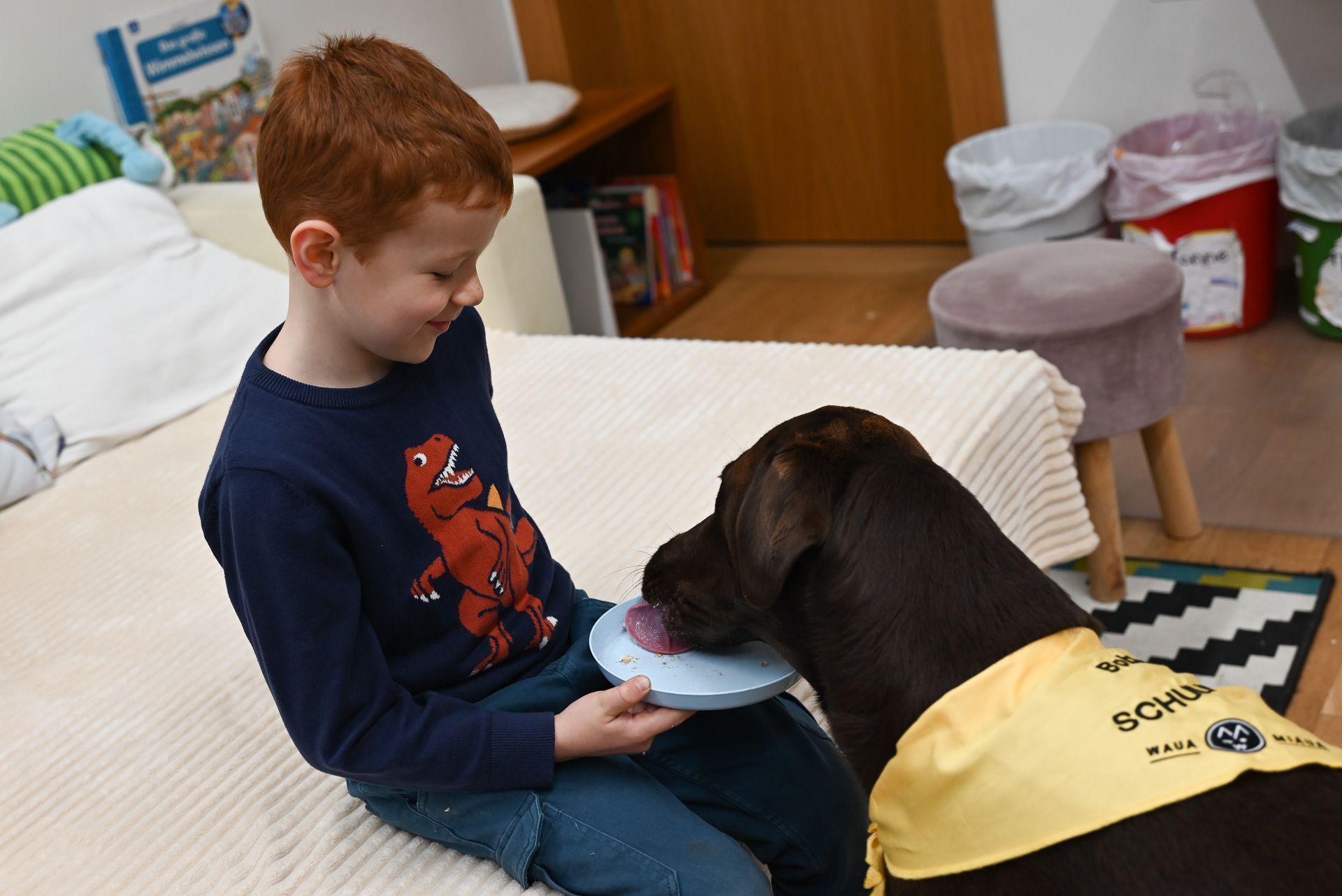 Die Kinder haben eine essbares Bild für Bobby auf einen Teller zusammengestellt und üben das freie Erzählen, während er sich die Zutaten schmecken lässt.