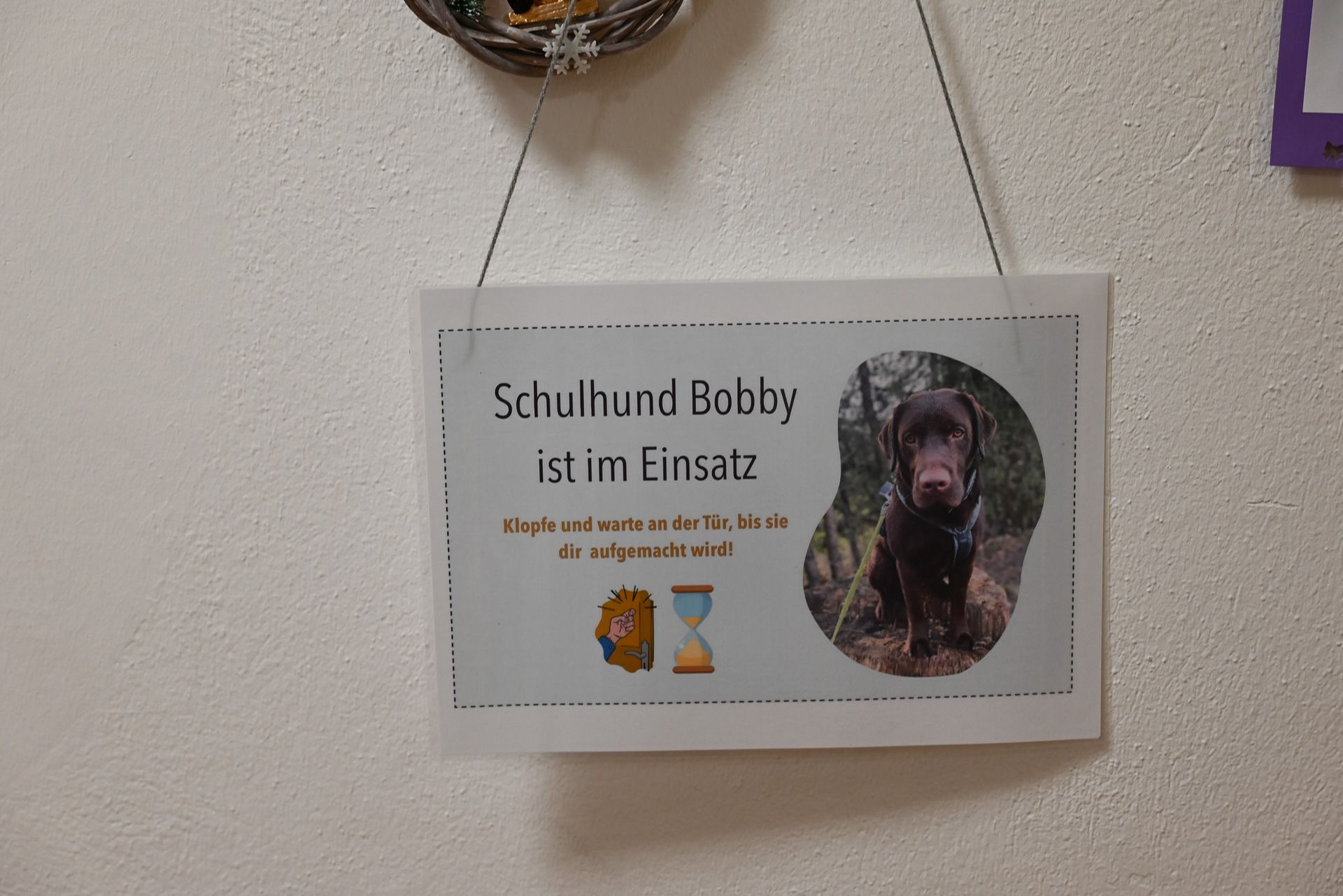 Ein Schild vor der Tür signalisiert, dass Schulhund Bobby im Raum ist.