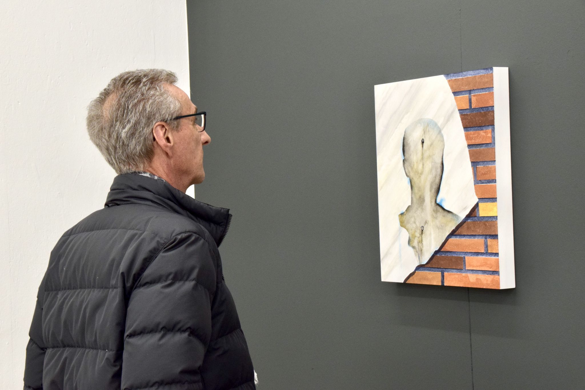 Edgar Winkler betrachtet ein Kunstwerk von Markus Proschek.