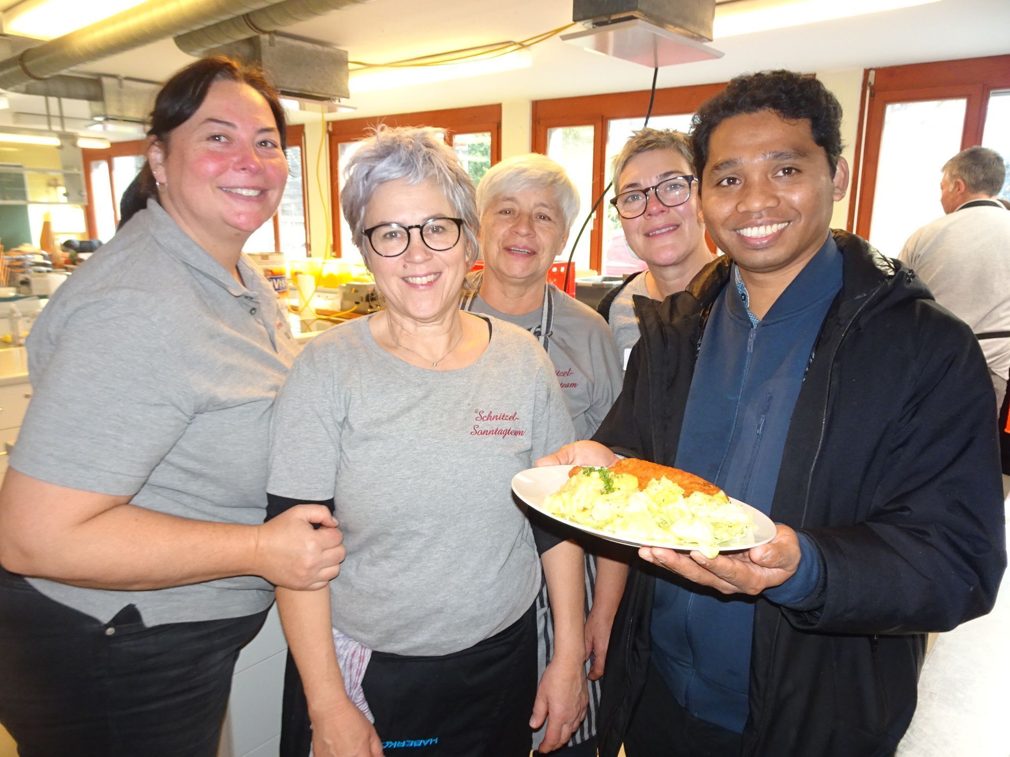 Pfarrer Inosens freute sich mit den fleißigen Damen, dass der Schnitzelsonntag wieder so gut ankam.