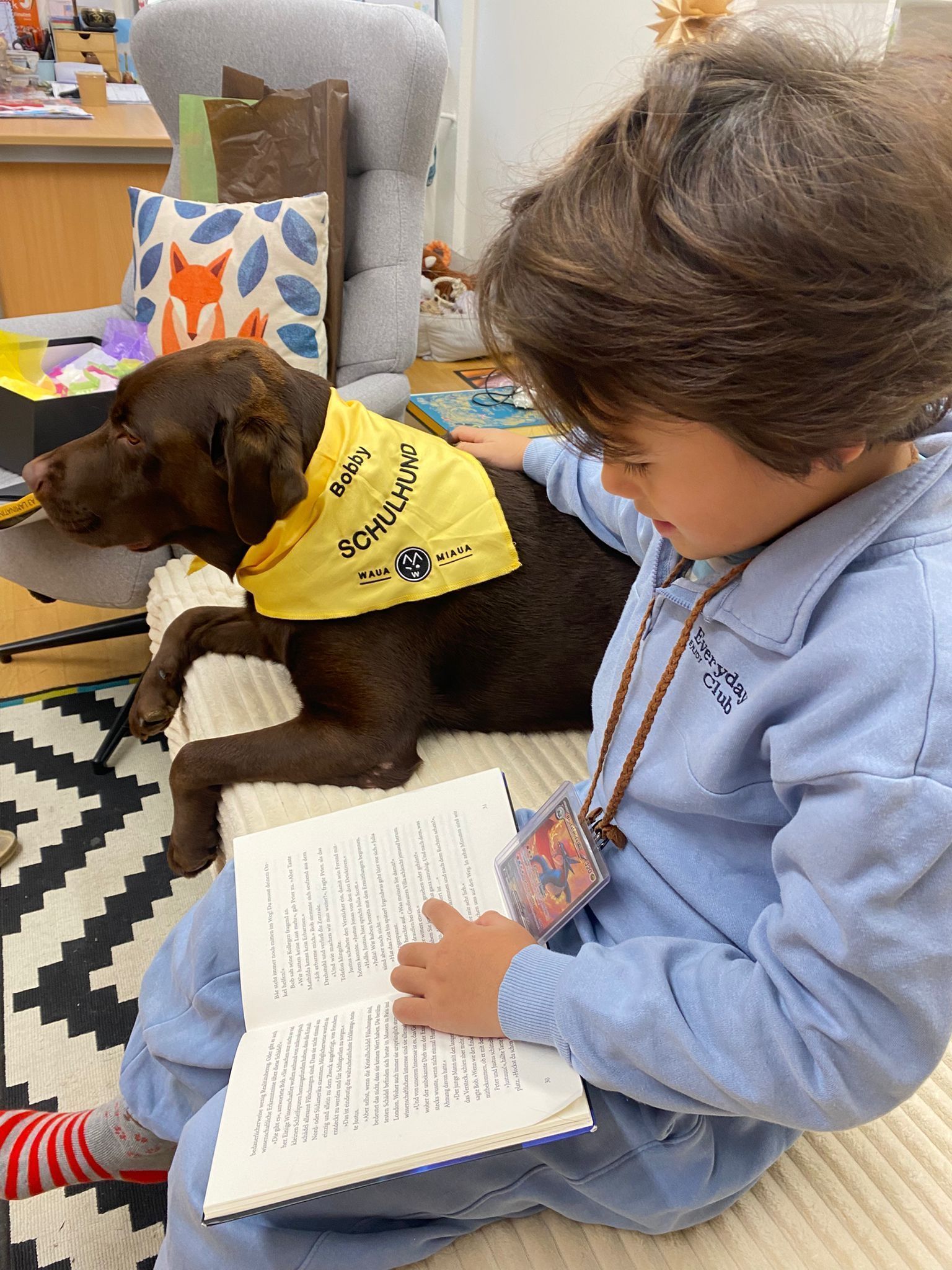 Die Kinder üben laut lesen und Bobby lauscht den Geschichten der Kinder.