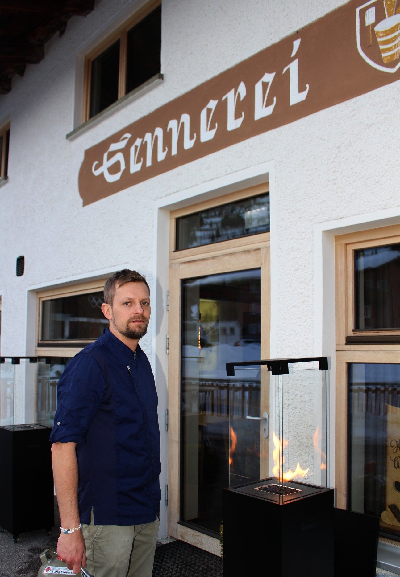 Michel Niesporek mit der High-tech-Feuerschale am Eingang, die zum Besuch der alten Sennerei einladen soll.   