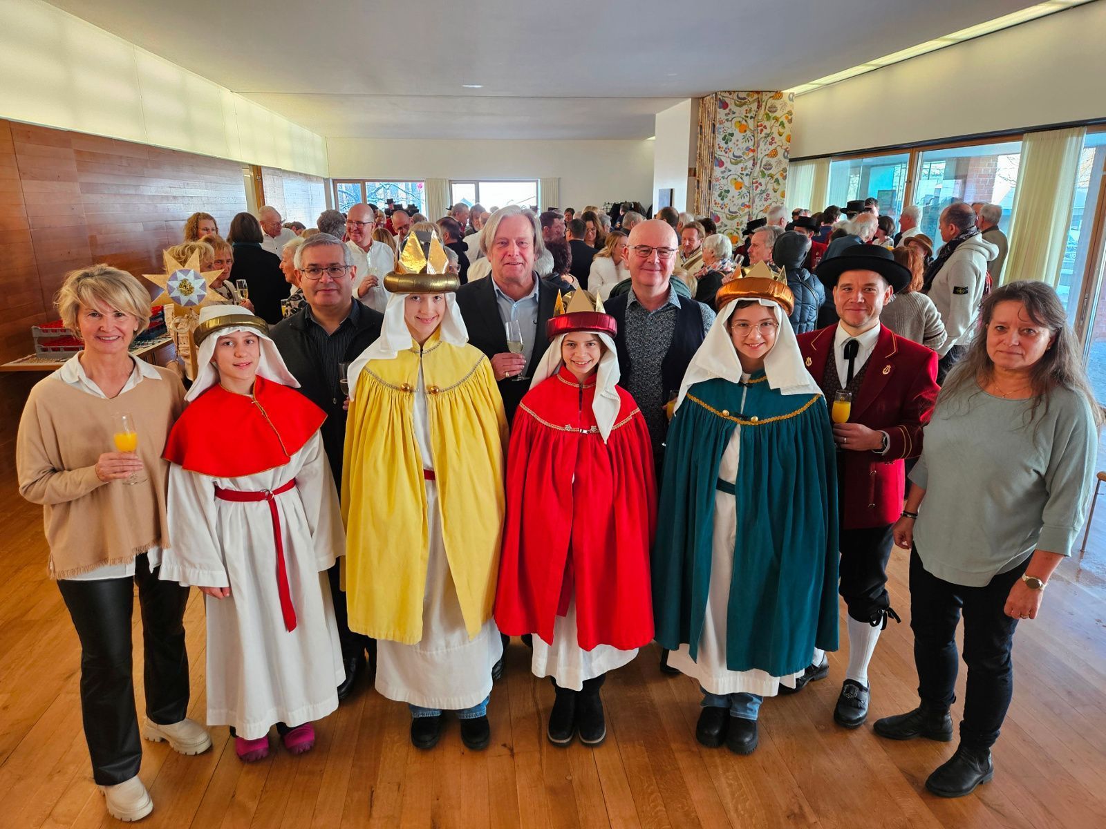 Ein Prosit auf ein glückliches und gesundes neues Jahr 2026: Chorleiterin Bernadette Oberscheider, Pfarrer Romeo Pal, Bürgermeister Frank Matt, Vizebürgermeister Stephan Schnetzer, Kapellmeister Rafael Ohmayer und Sonja Reichart mit den Sternsingern.